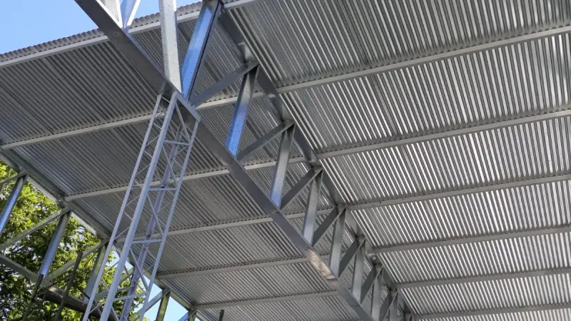 Vista parcial: detalle desde abajo de una cercha reticulada y las correas que sostienen la chapa