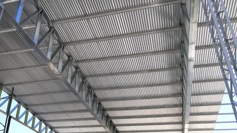 Otro ángulo: detalle desde abajo de una cercha reticulada y las correas que sostienen la chapa