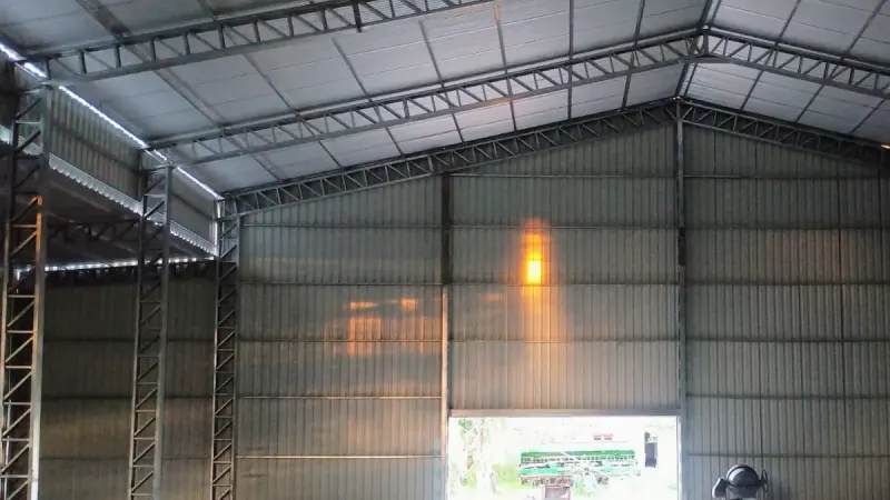 Vista parcial: interior vacío de un galpón cerrado con piso de hormigón y portón al fondo