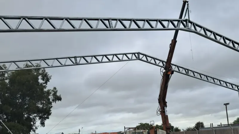 Vista parcial: izaje de cerchas con hidrogrúa montada en camión durante el montaje