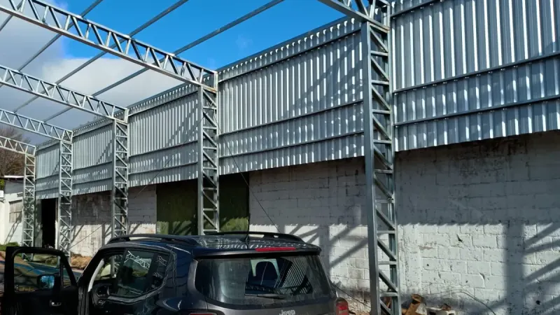 Otro ángulo: montaje de cerramiento lateral de chapa sobre un muro existente