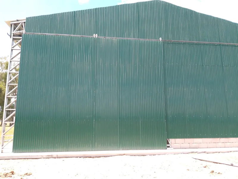 Portón corredizo de dos hojas en un galpón de chapa verde