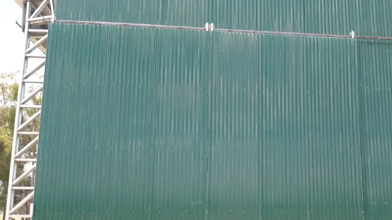 Vista parcial: portón corredizo de dos hojas en un galpón de chapa verde