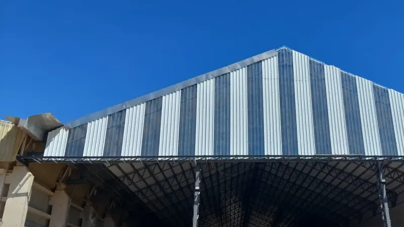 Vista parcial: cubierta de tinglado con franjas de chapa traslúcida intercaladas con chapa galvanizada