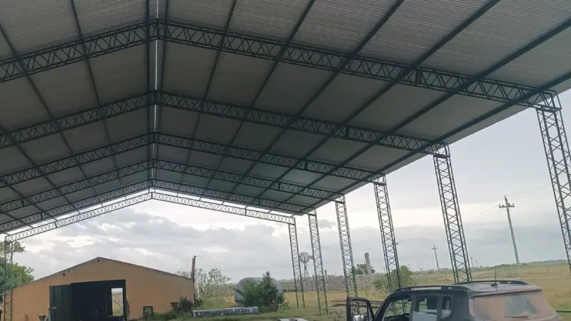 Otro ángulo: tinglado rural abierto con cubierta de chapa verde y columnas galvanizadas